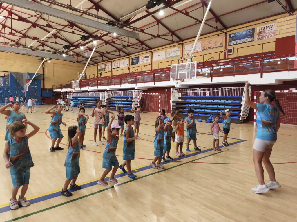 Profe dando clases de baile en el pabellon durante el campamento deportivo bilingue de torrox